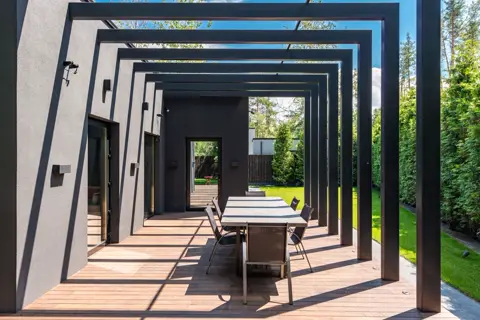 Een terras onder een moderne overkapping.